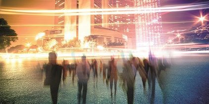 People walking with night lit buildings behind