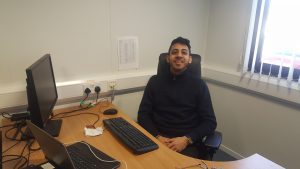 Raj Clair at his desk smiling