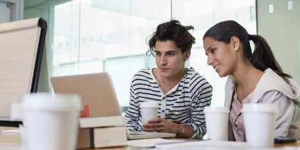 University students drinking coffee and using laptop