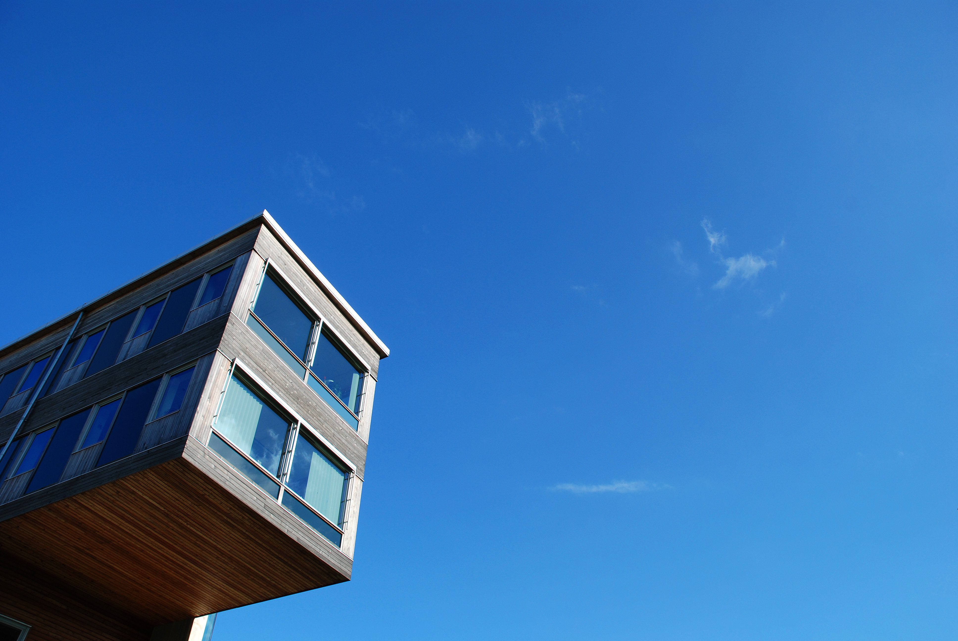 The cantelevered edge of a building against blue sky