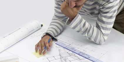 A man poring over architectural floor plans