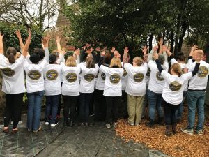 Staff members altogether raising their hands for a picture Staff members in the Purley Park garden