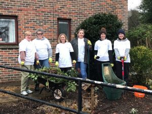 Staff members holding gardening equipment in the Purley Park garden