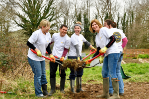 Staff digging up a large clod of earth