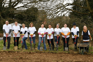 Group of staff leaning on garden forks