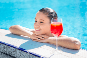 Woman in a swimming pool with a drink