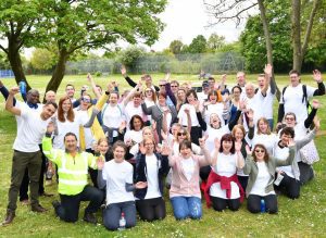 All 50 members of staff at Courage Park with their hands up