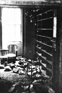 An image showing the post room after the raid in 1941 with documents strewn on the floor and the bookshelves bare