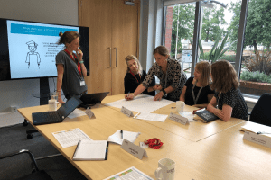 One of the two groups working on a drawing of a modern student