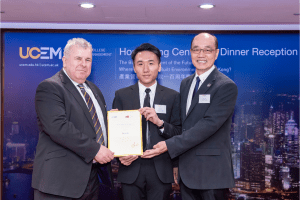 UCEM Dean of the Built Environment, Tim Bennett, presents a scholarship to a CityU student and a representative from the university