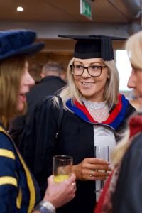 A graduate in a conversation at the December 2019 UCEM Graduation