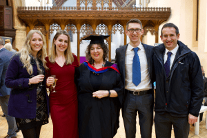 A graduate and her family smiling for the camera at the December 2019 UCEM Graduation