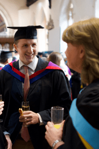 A graduate shares a joke at the December 2019 UCEM Graduation