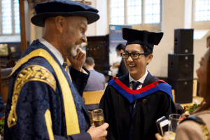 A graduate shares a joke with UCEm Principal, Ashley Wheaton, at the December 2019 UCEM Graduation