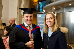 A graduate and friend celebrate at the December 2019 UCEM Graduation