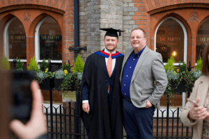 A graduate poses for a photo with a family member at the December 2019 UCEM Graduation