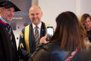 A graduate poses for a photo with UCEM Principal, Ashley Wheaton, at the December 2019 UCEM Graduation