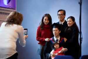 A graduate poses for a photo with his family at the December 2019 Graduation