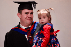 A graduate with his daughter at the December 2019 UCEM Graduation