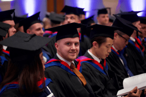 A graduand sat in his seat before the December 2019 UCEM Graduation ceremony