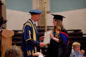 A graduate award winner with UCEM Principal, Ashley Wheaton, at the December 2019 UCEM Graduation