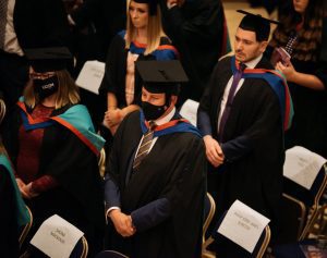 Graduands stood by their seats