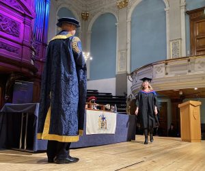 A graduand walks across the stage