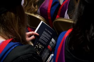 A graduand reads the brochure