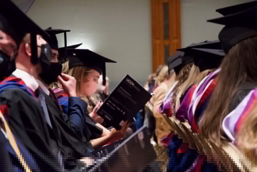 A graduand reads the graduation brochure