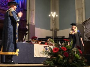 A graduand walks across the stage