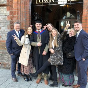 Graduate and family pull funny faces