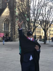 A graduand lofts his mortar board into the air