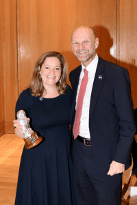 Nicola holding her Alumni Award and stood next to UCEM Principal, Ashley Wheaton